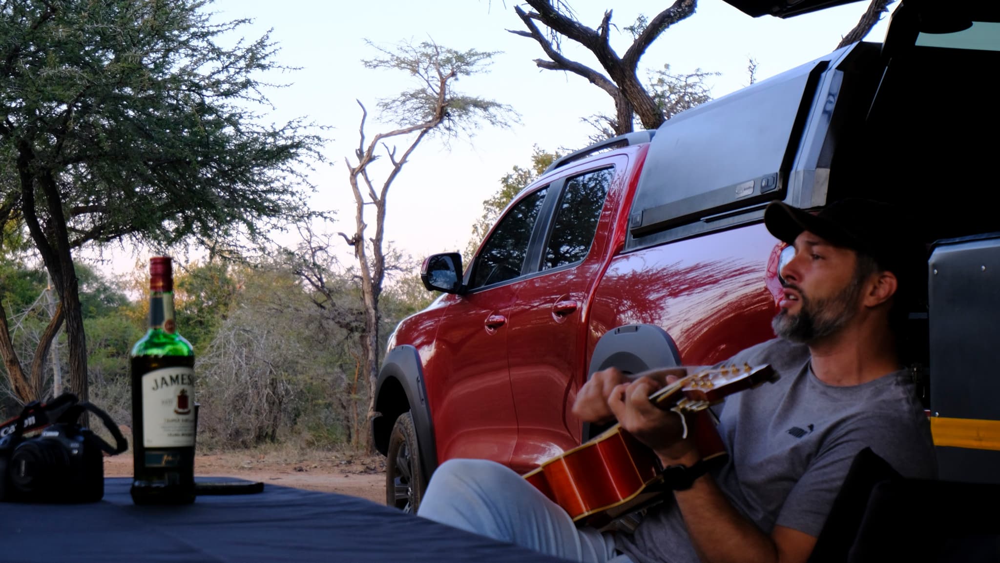 Guest playing guitar at Bush Camp during golden hour