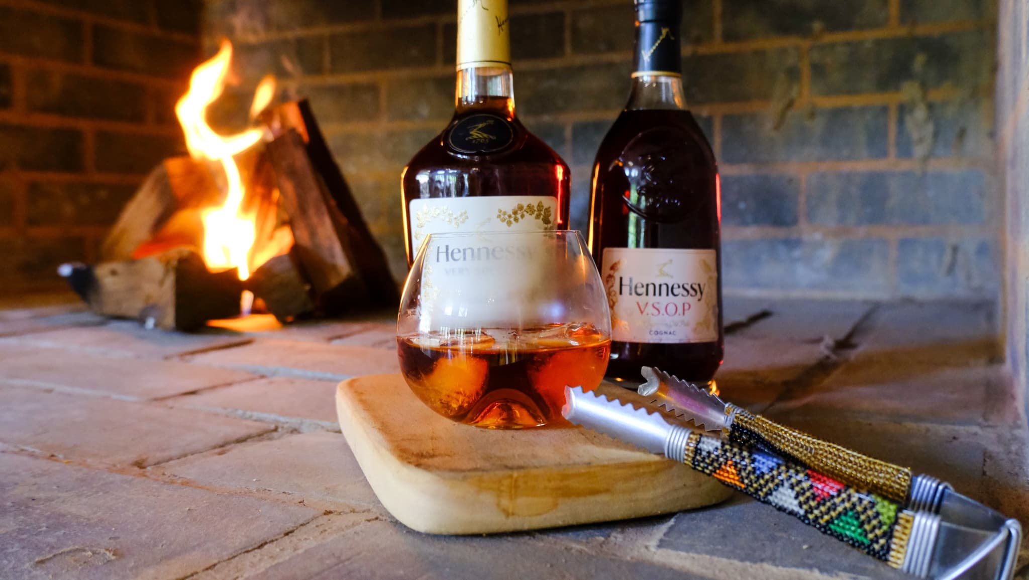 Hennessy cognac by the fireplace with beaded tongs