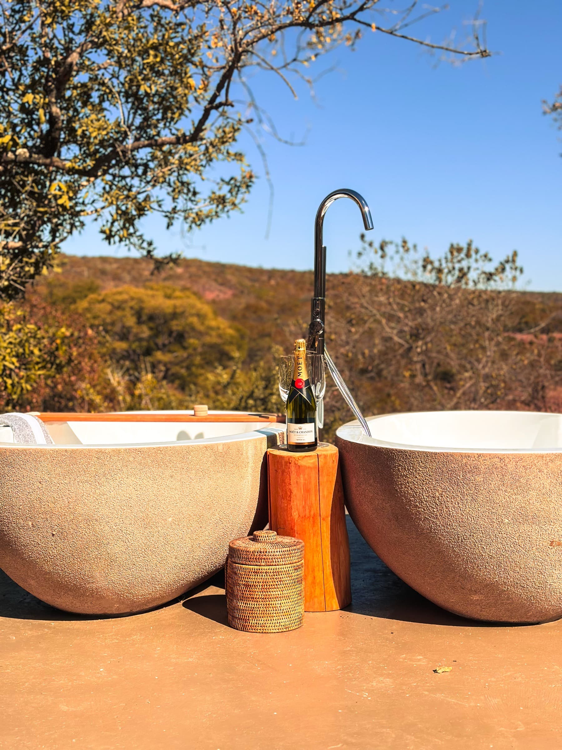 Twin outdoor stone bathtubs with Moët champagne